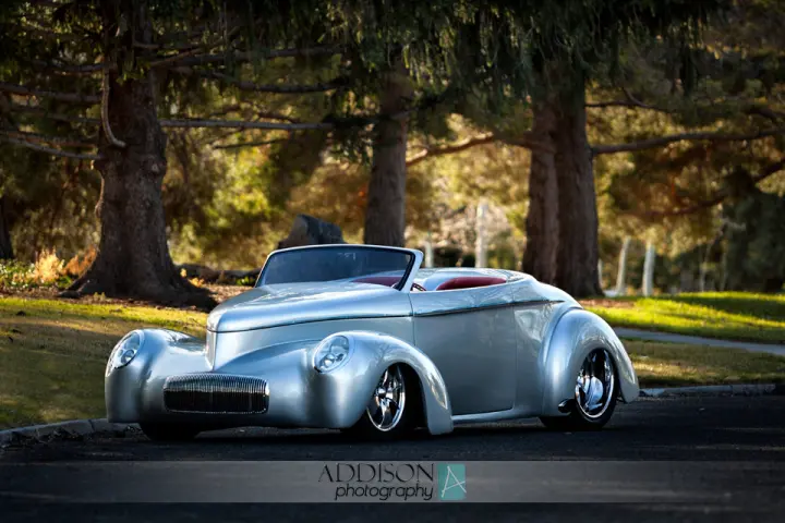 A silver '41 Willys Roadster outdoors in the fading sunlight.